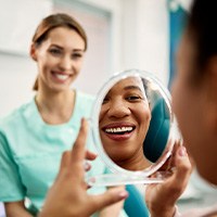 Patient smiling at reflection in treatment chair