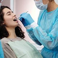 Dentist performing dental bonding on female patient