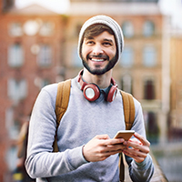 Man with dental crown in Carlisle smiling while walking outside