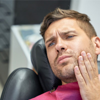Patient with toothache sitting in treatment chair