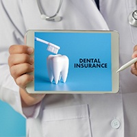 A dentist holding a tablet that says dental insurance