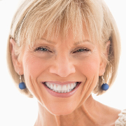 woman with blue earrings smiling