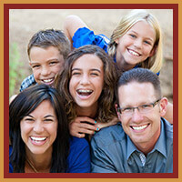 family of five smiling and laughing