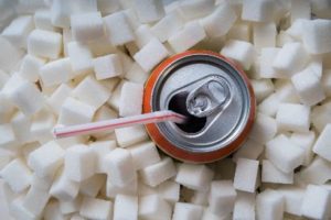 Soda can surrounded by sugar cubes