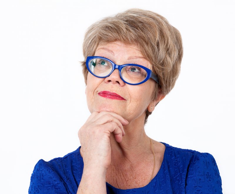 older woman smiling wearing blue glasses