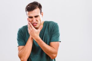 man holding jaw in pain