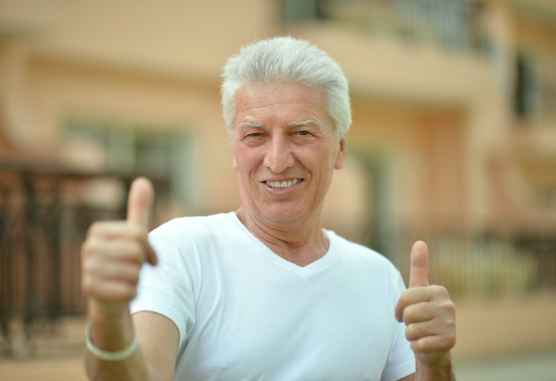 older man smiling thumbs up