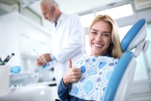 woman giving thumbs up while seeing dentist