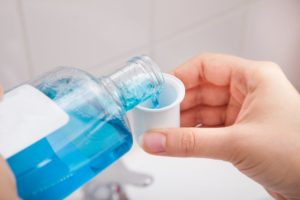 person pouring mouthwash into cup