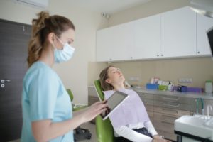 Female hygienist at dentist wearing a mask.