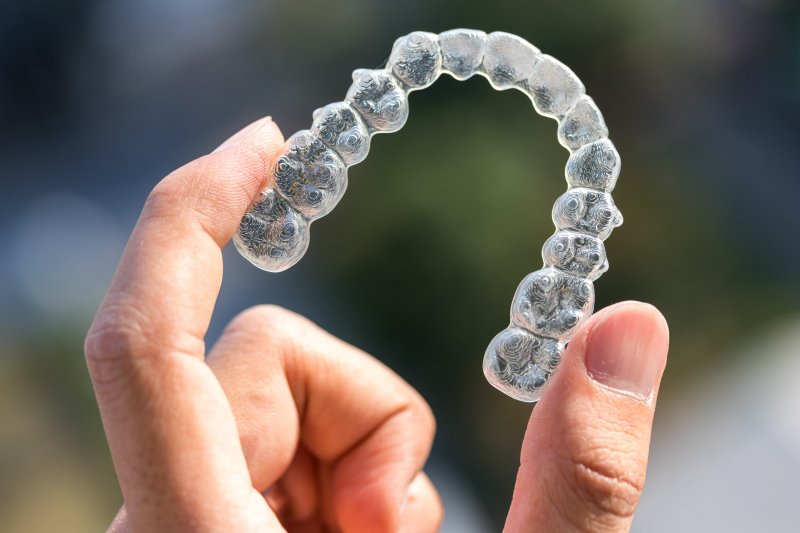 closeup of someone holding up an Invisalign aligner