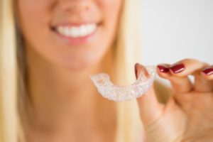 woman holding invisalign