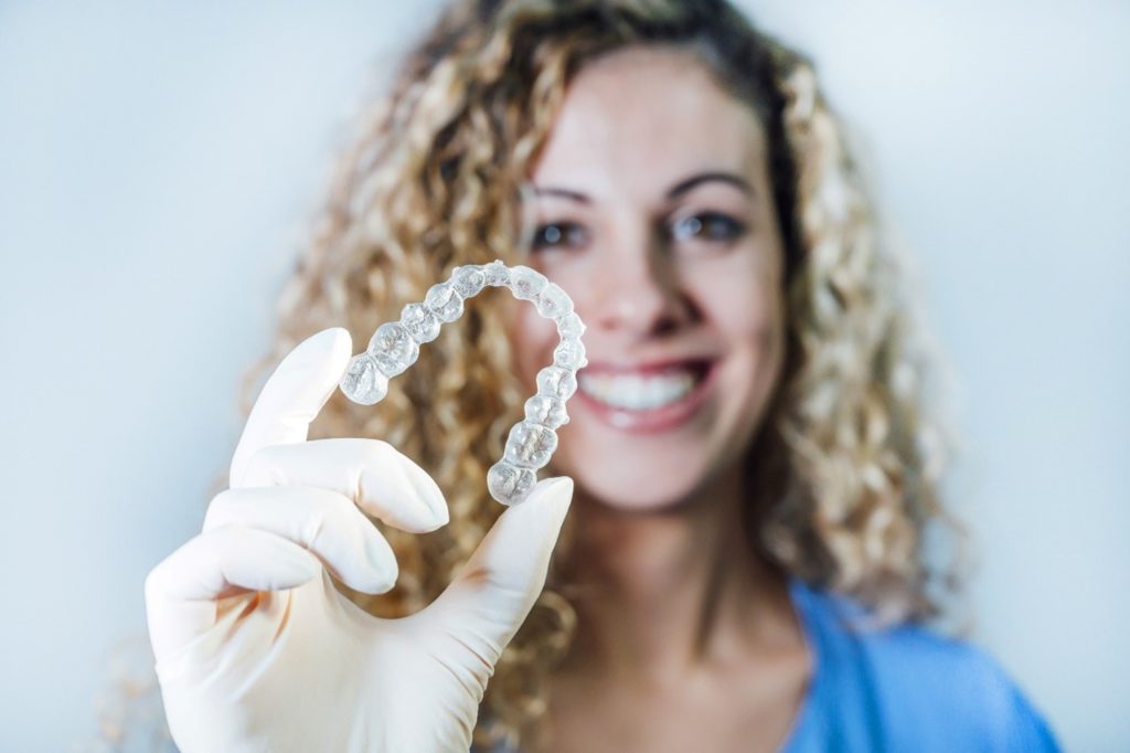 Female dentist holding Invisalign tray