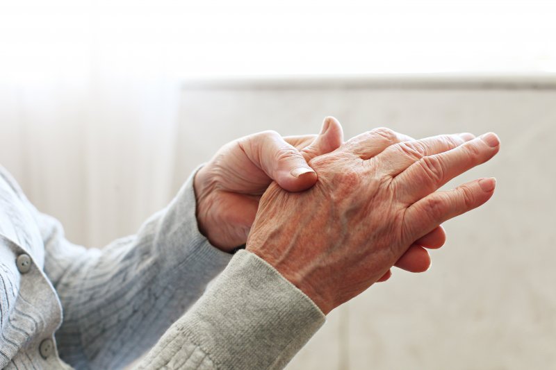 A person rubbing their hands due to their rheumatoid arthritis