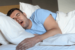 Man with sleep apnea snoring like a bear in his bed